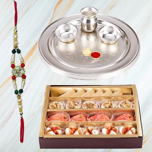 Assorted Sweets and Stylish and Trendy looking Silver Plated Paan Shaped Puja Aarti Thali along Rakhi, Roli, Tilak and Chawal